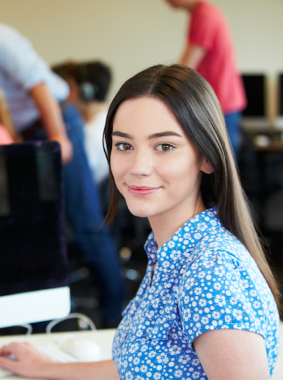 Female student smiling in front of computer