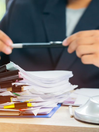 paralegal at desk reviewing stack of records