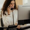 Student working - answering phone while on computer