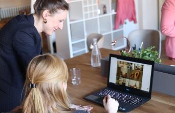 two girls at a computer smiling