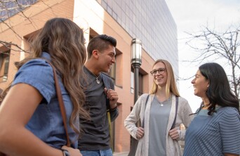 Students in a circle smiling outside Ensign College