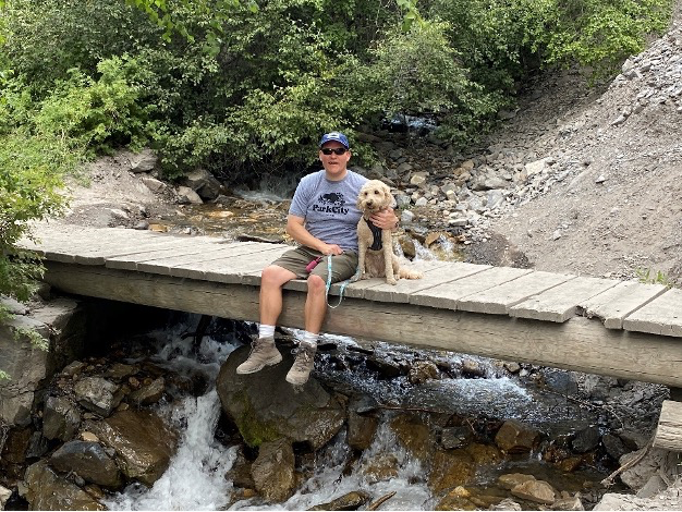 Michael Grooms with his dog on a primitive rural trail bridge