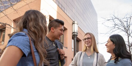 Students in a circle smiling outside Ensign College
