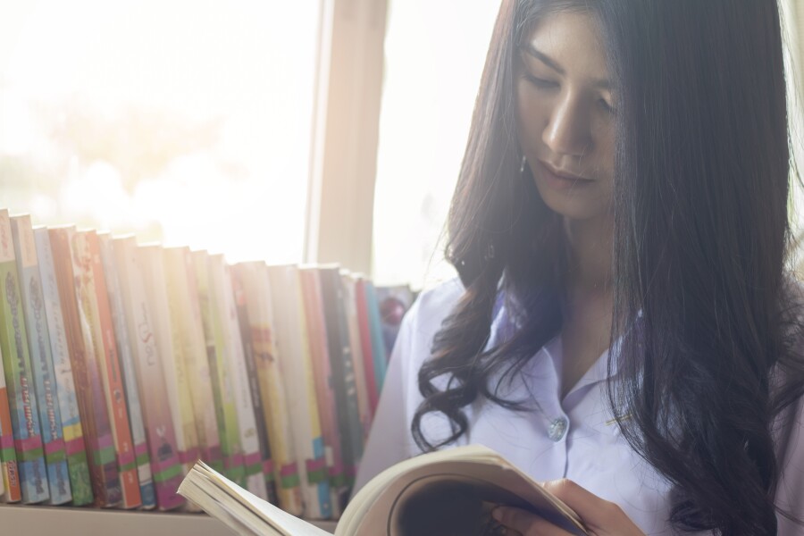 Student reading a book in the library