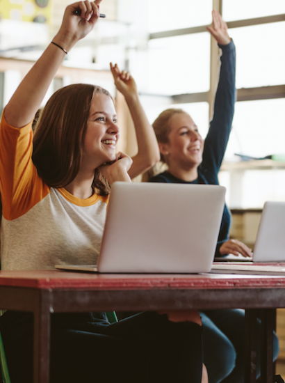 high school students raising hands in class