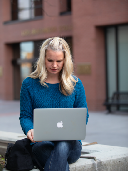 female student on laptop on campus