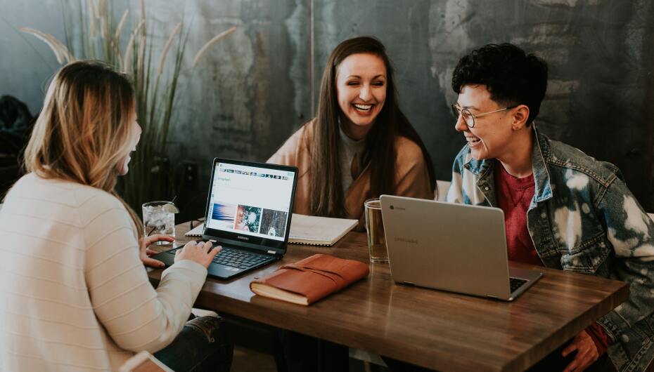 Laughing students on laptops